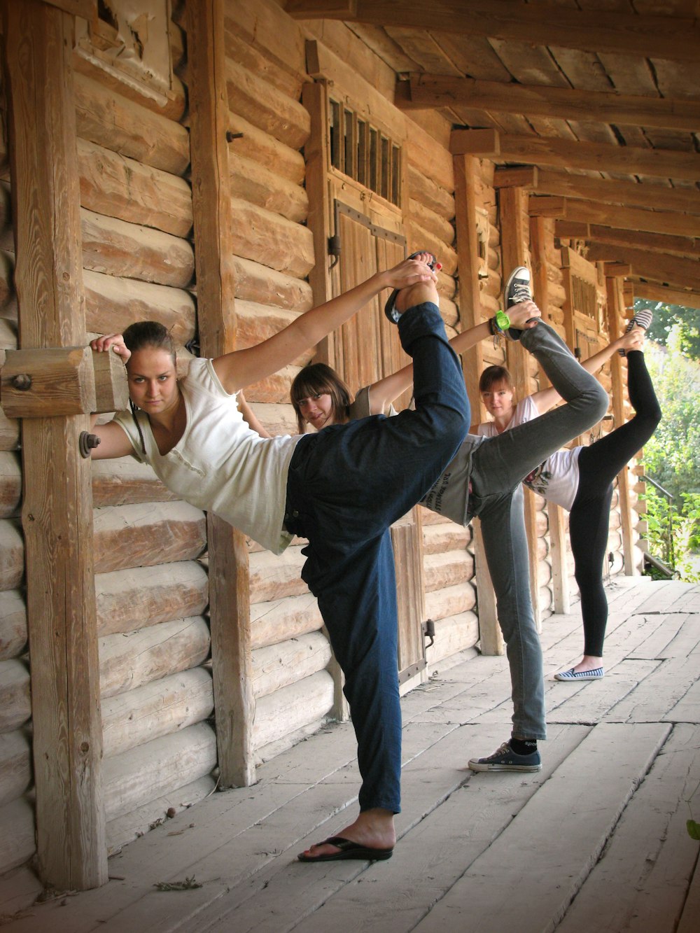 a group of people doing yoga in front of a log cabin