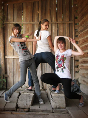 Friends striking playful poses in front of the 360 video booth with warm golden lighting.