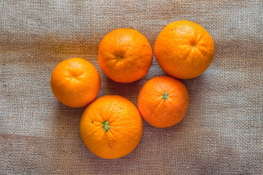 a group of four oranges sitting on top of a table