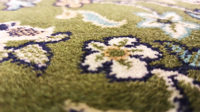 Close-up of a soft, patterned carpet with intricate floral designs in earth tones.