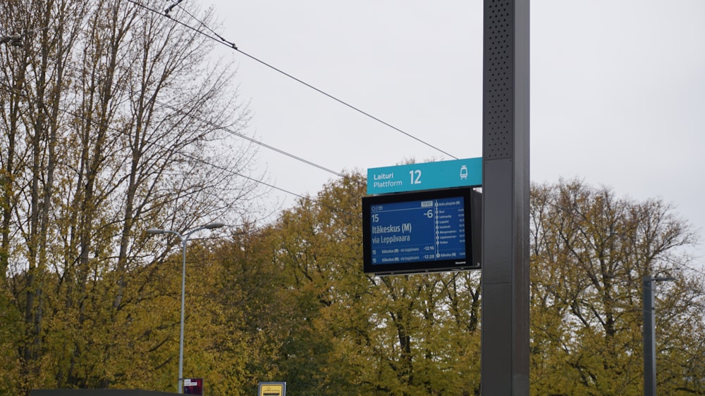a blue sign hanging from the side of a metal pole