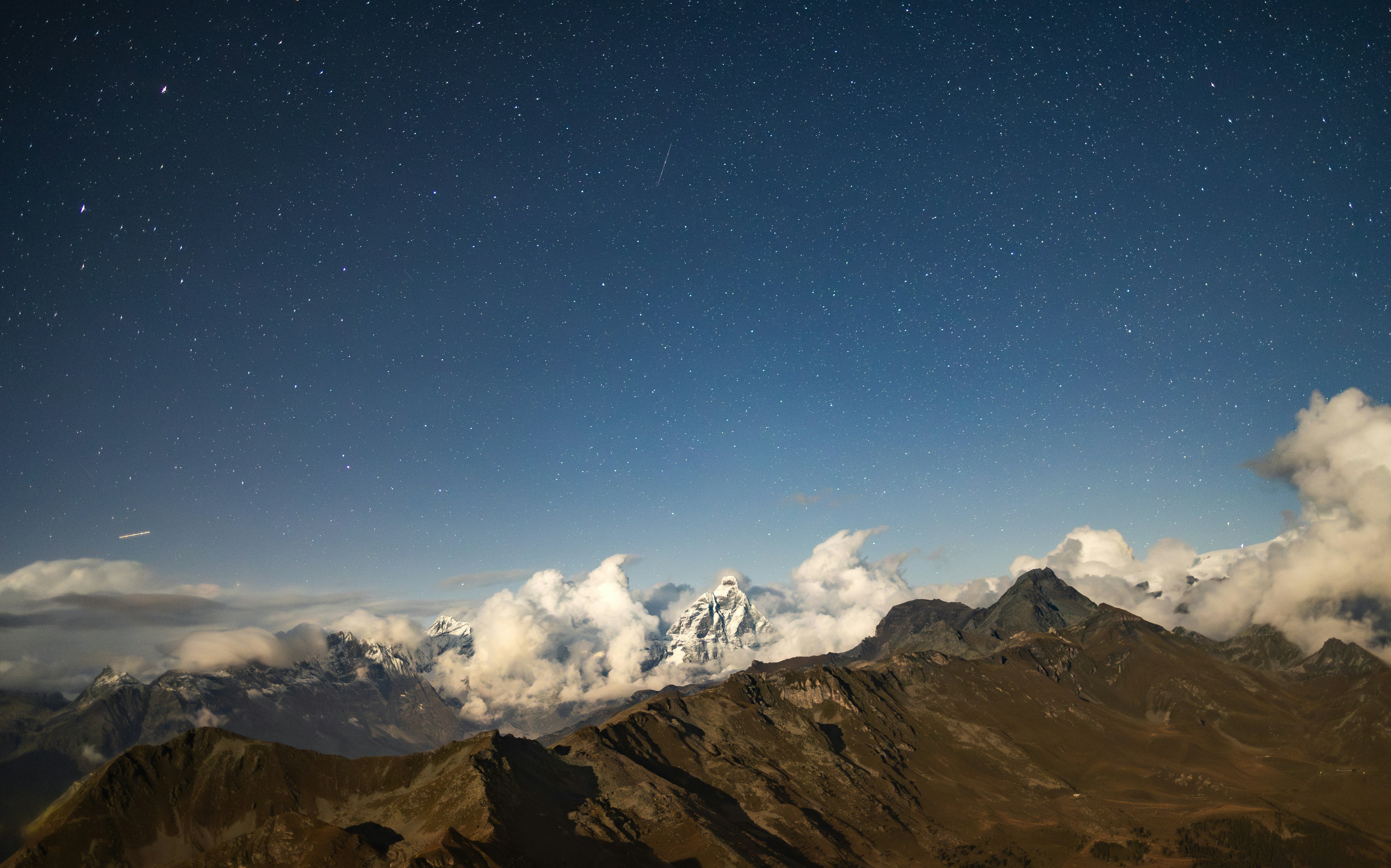 The night sky over a mountain range with clouds and stars photo – Free ...