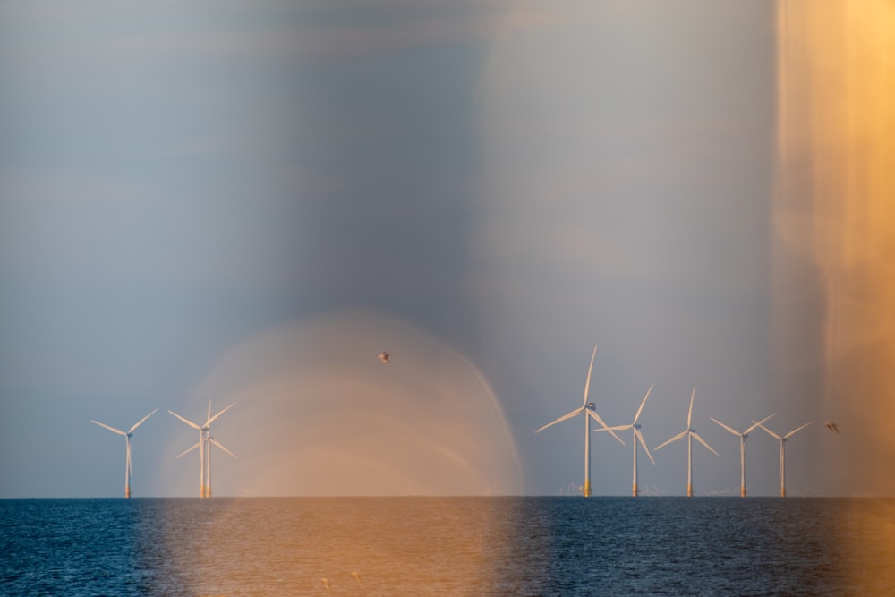 a group of wind turbines in the ocean