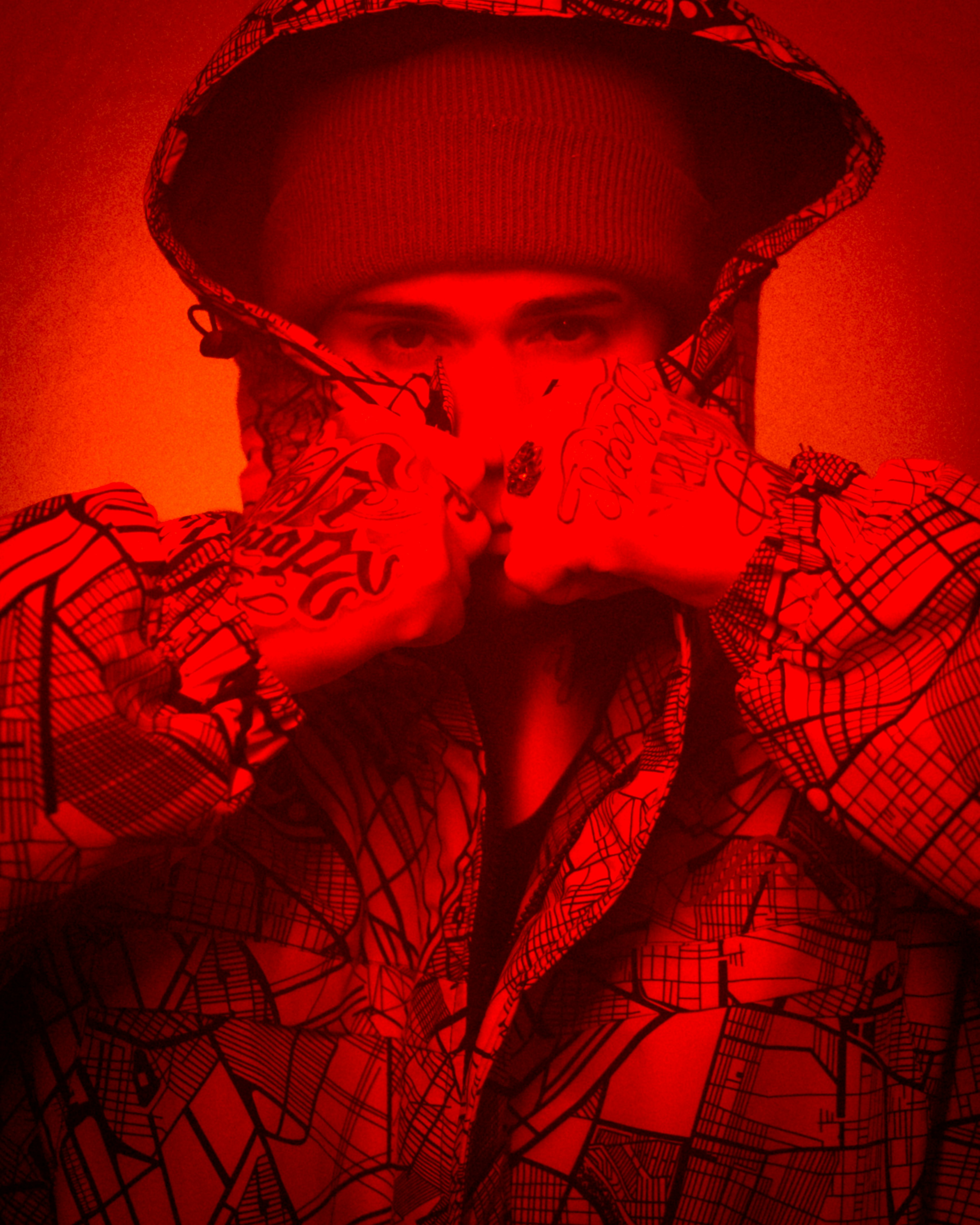 A man in a red shirt and hat covering his face with his hands photo ...