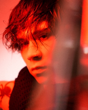 Softly lit portrait highlighting freckles tattoo on cheeks and nose.