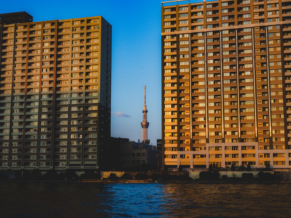 a couple of tall buildings next to a body of water