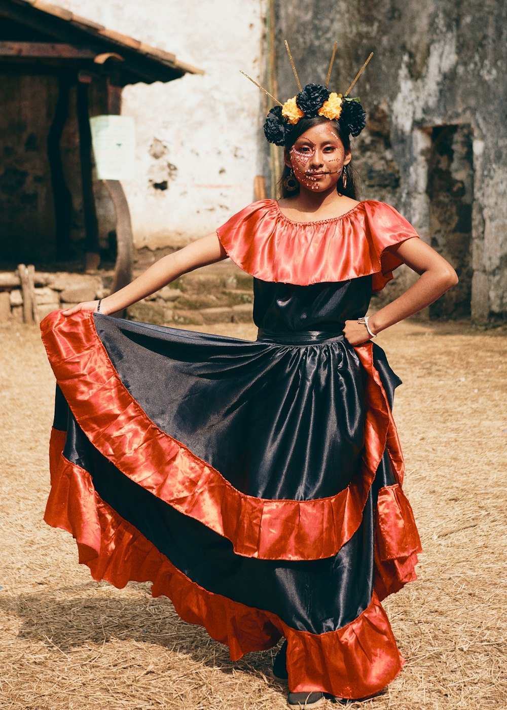 a woman in a long dress standing in the dirt