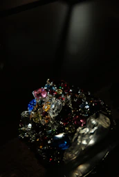 A collection of certified fancy colored diamonds and gemstones arranged artfully with hints of red and white accents.