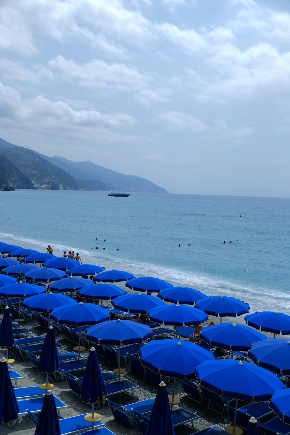 a bunch of blue umbrellas that are on a beach