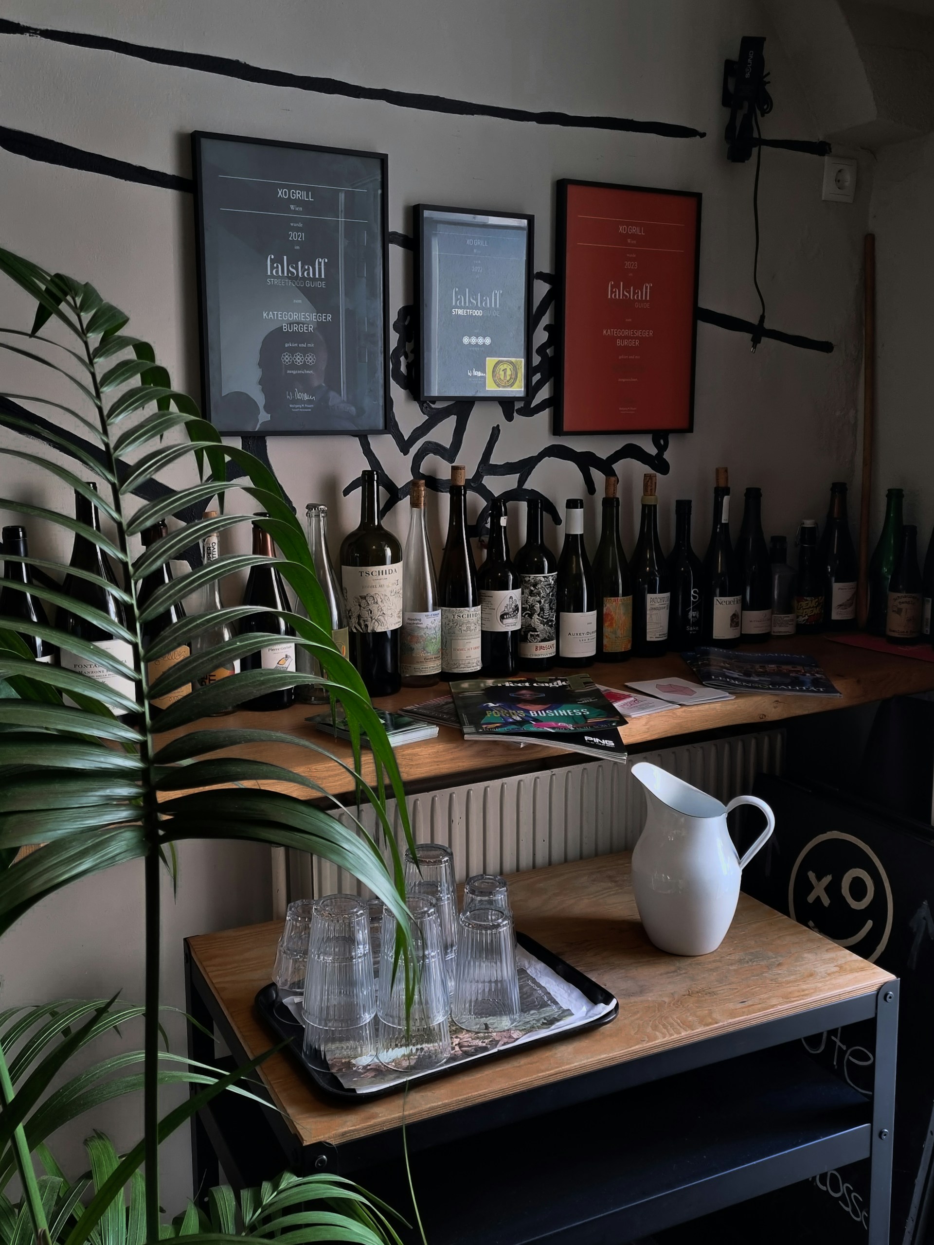 A rustic tasting table set with various wine bottles and glasses, surrounded by warm lighting inside the vinoteca.