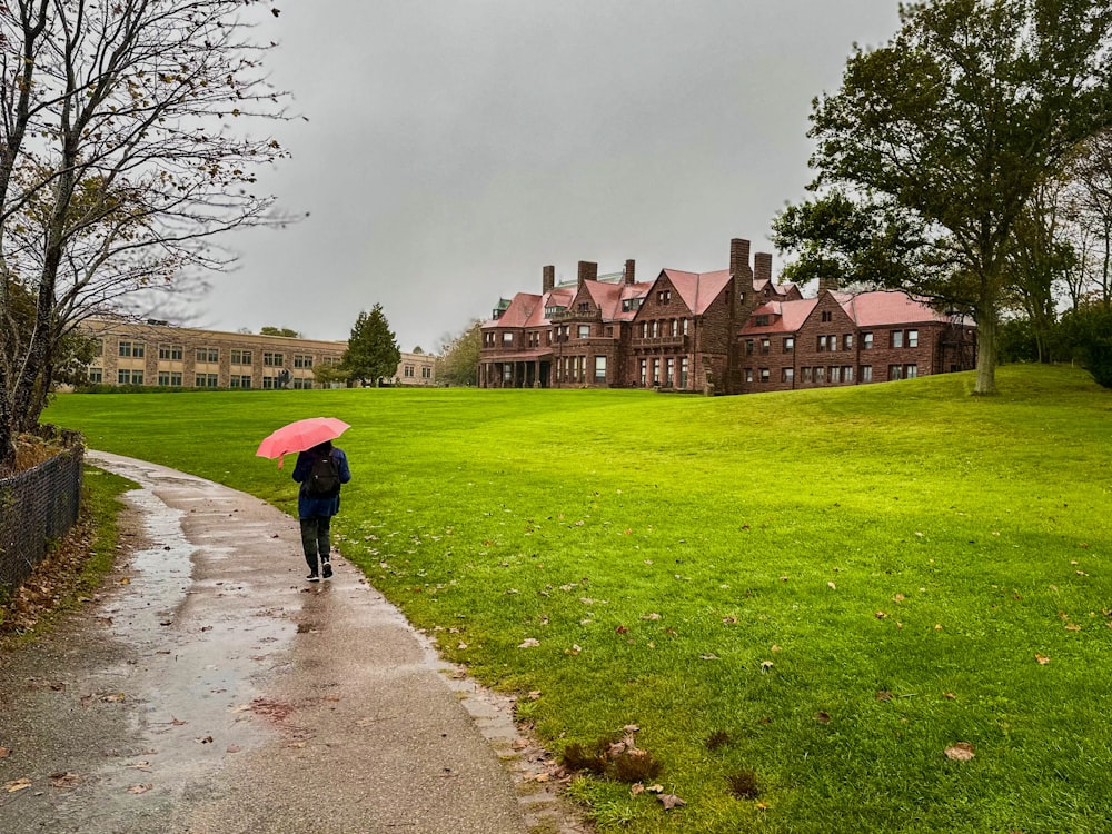 a person walking down a path with a pink umbrella