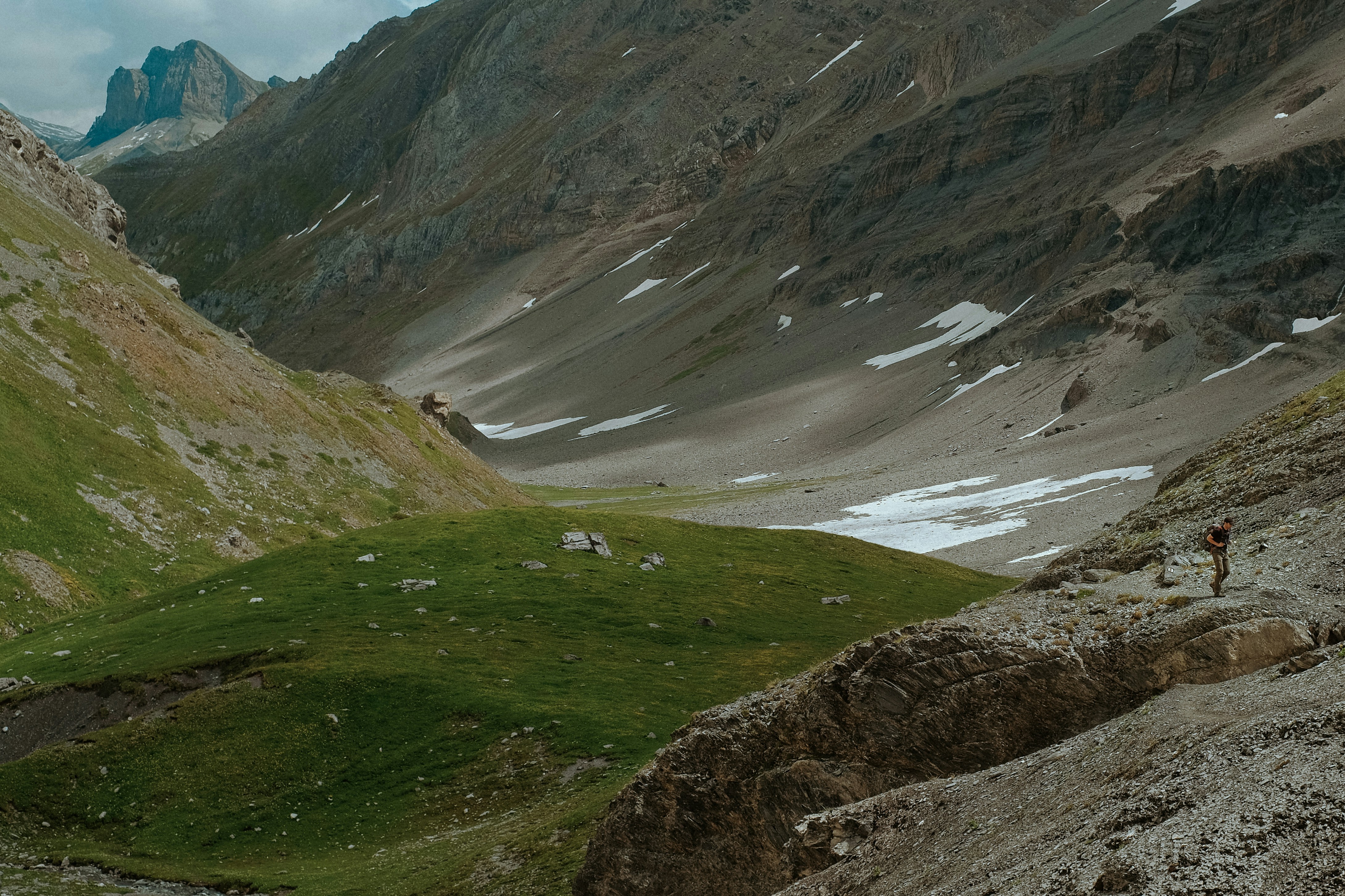 a man hiking up a hill in the mountains