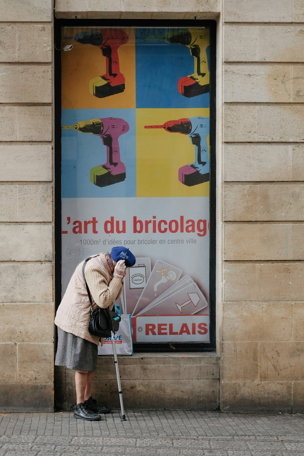 a woman leaning against a sign with a drill gun on it
