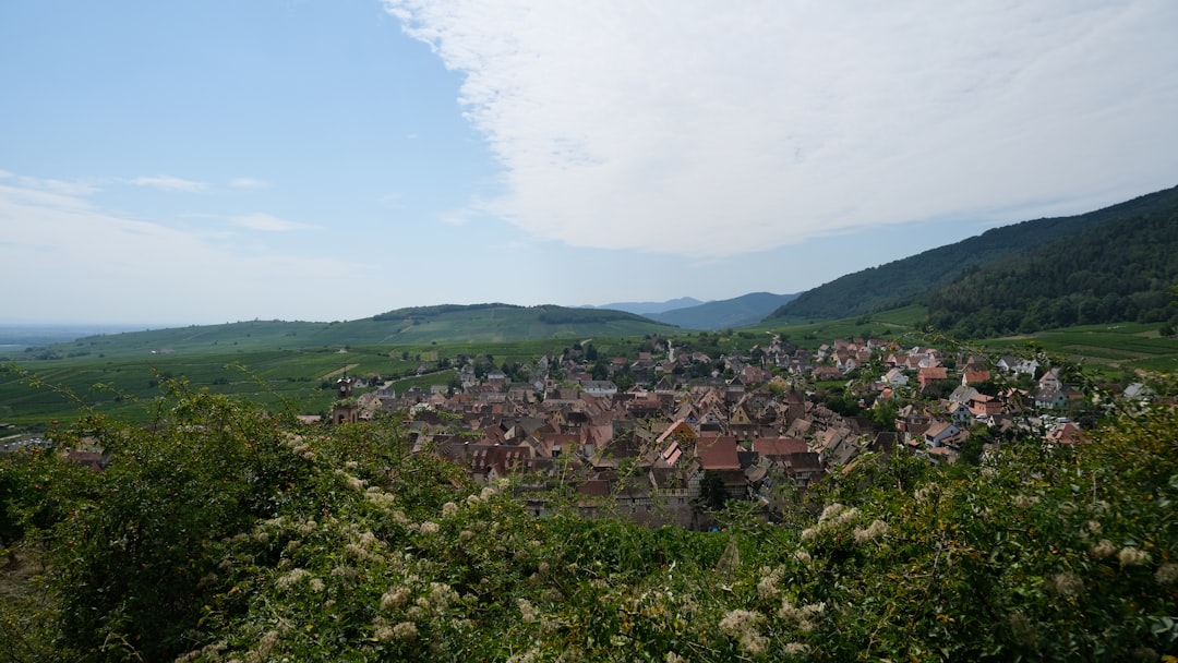 a village nestled in a valley surrounded by mountains,