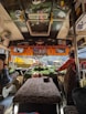 A cozy travel bus filled with passengers heading to a religious site.