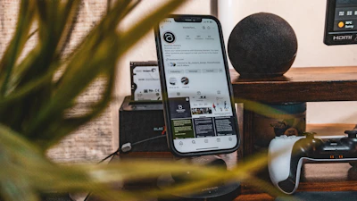 a cell phone sitting on top of a table next to a plant