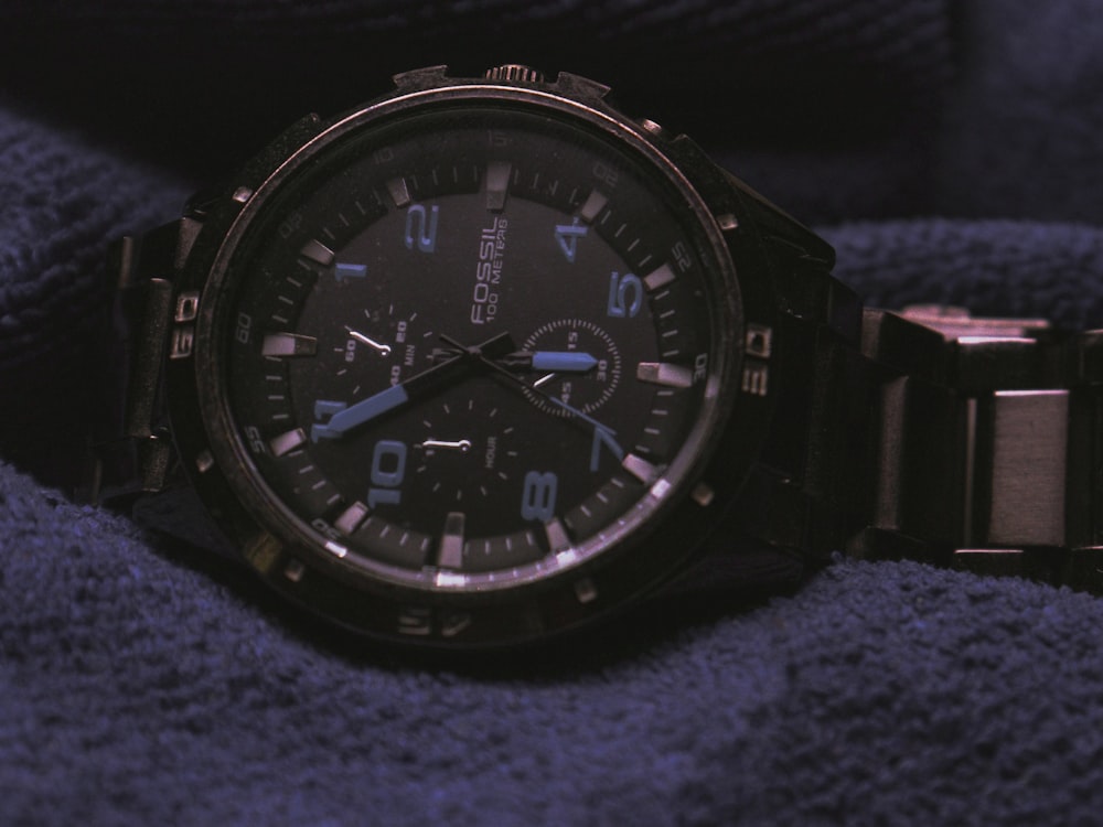 a watch sitting on top of a blue blanket