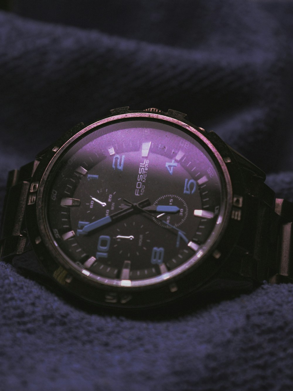 a watch sitting on top of a purple cloth