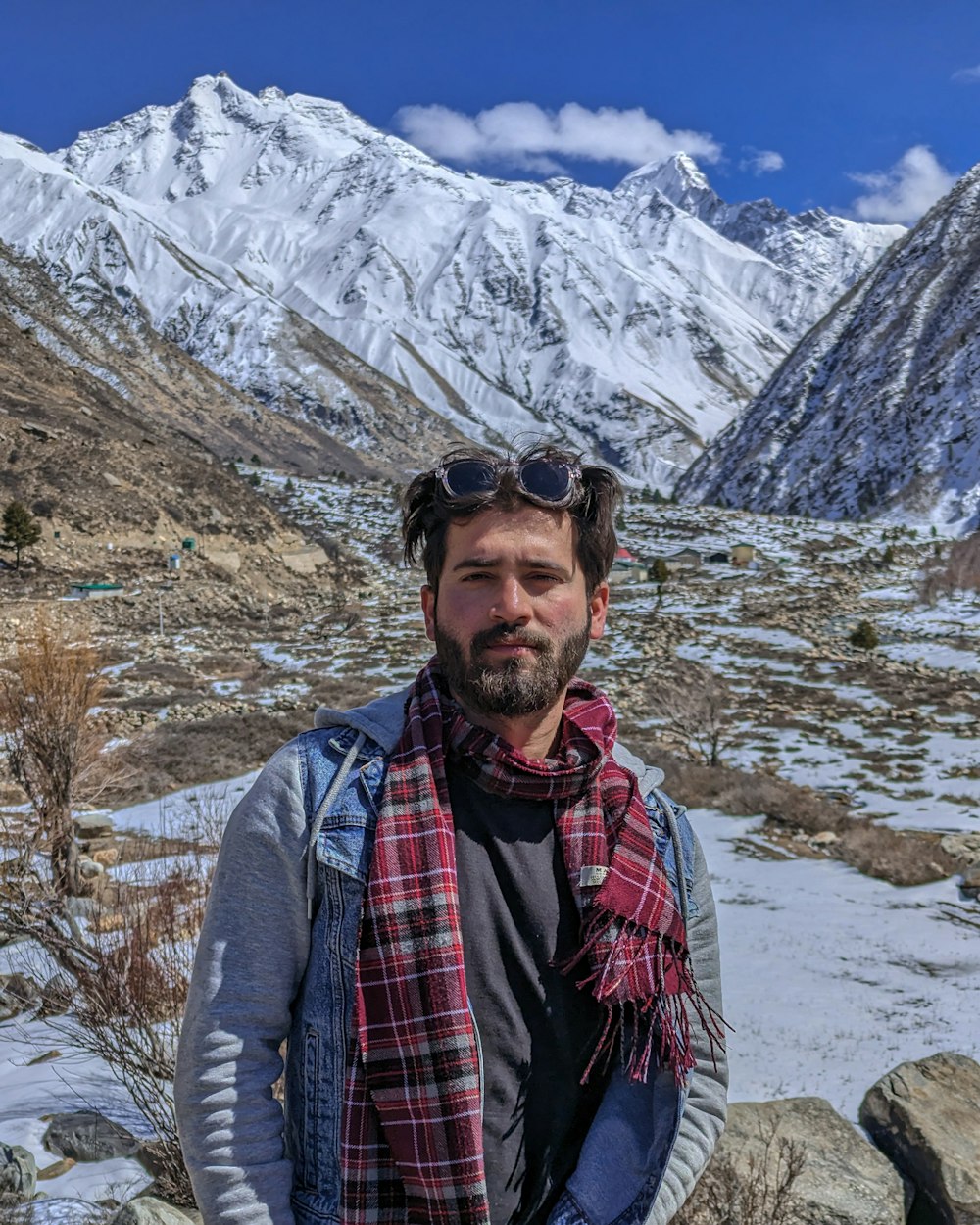 a man standing in front of a snow covered mountain