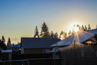 the sun is setting over a residential area