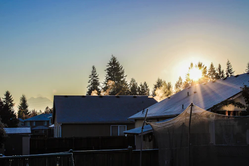 the sun is setting over a residential area