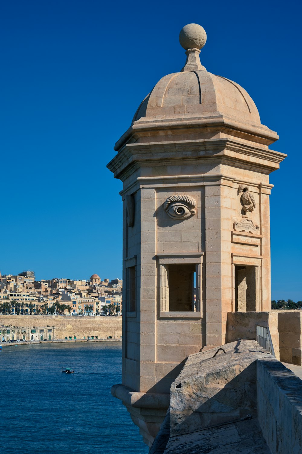 a clock tower with an eye on the top of it