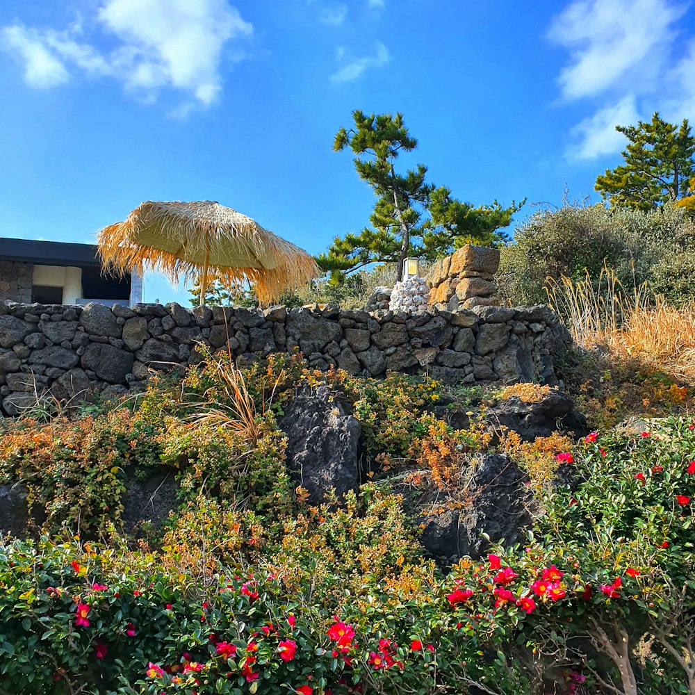 a stone wall with a straw umbrella over it