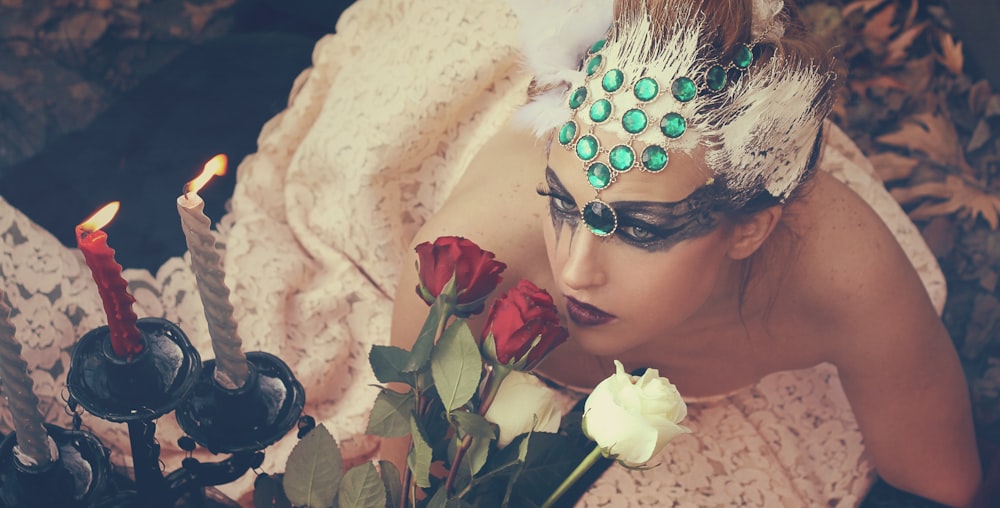 a woman laying on a bed with a bouquet of roses