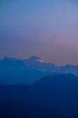 A serene mountain range bathed in the cool tones of early evening.