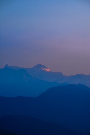 A peaceful mountain trail bathed in soft purple twilight.