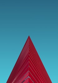 a red triangular shaped building against a blue sky