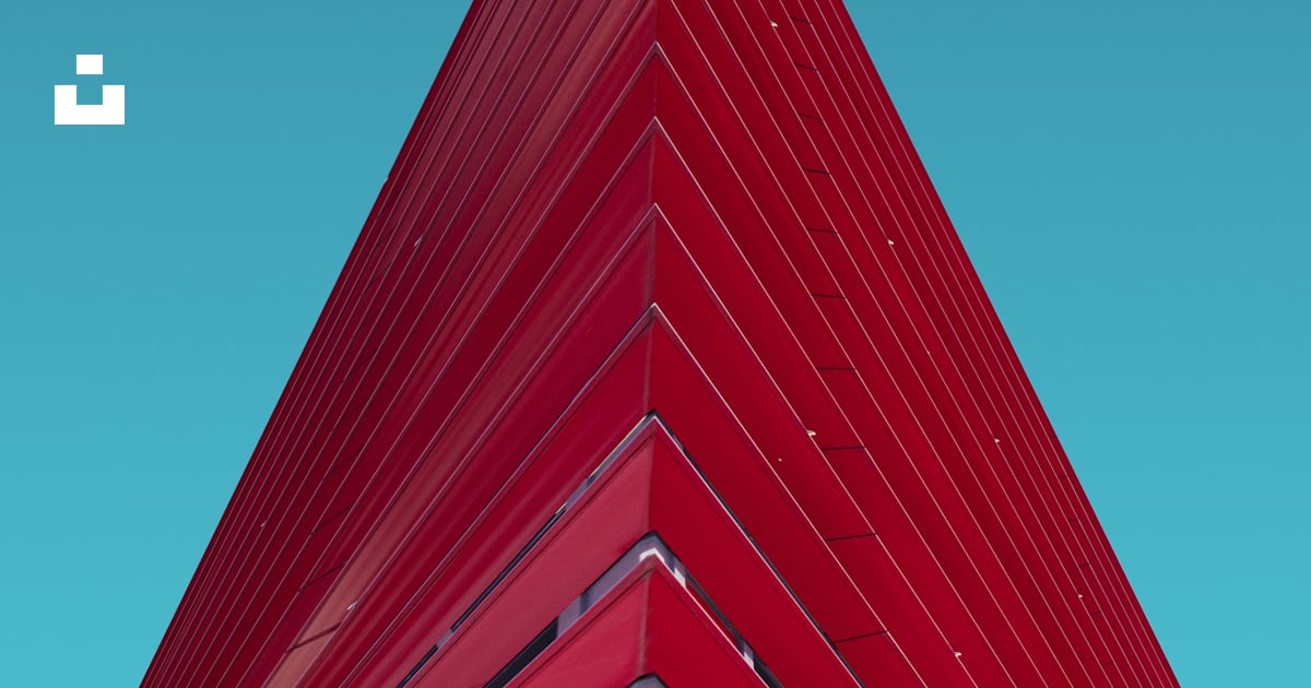 A red triangular shaped building against a blue sky photo – Free ...