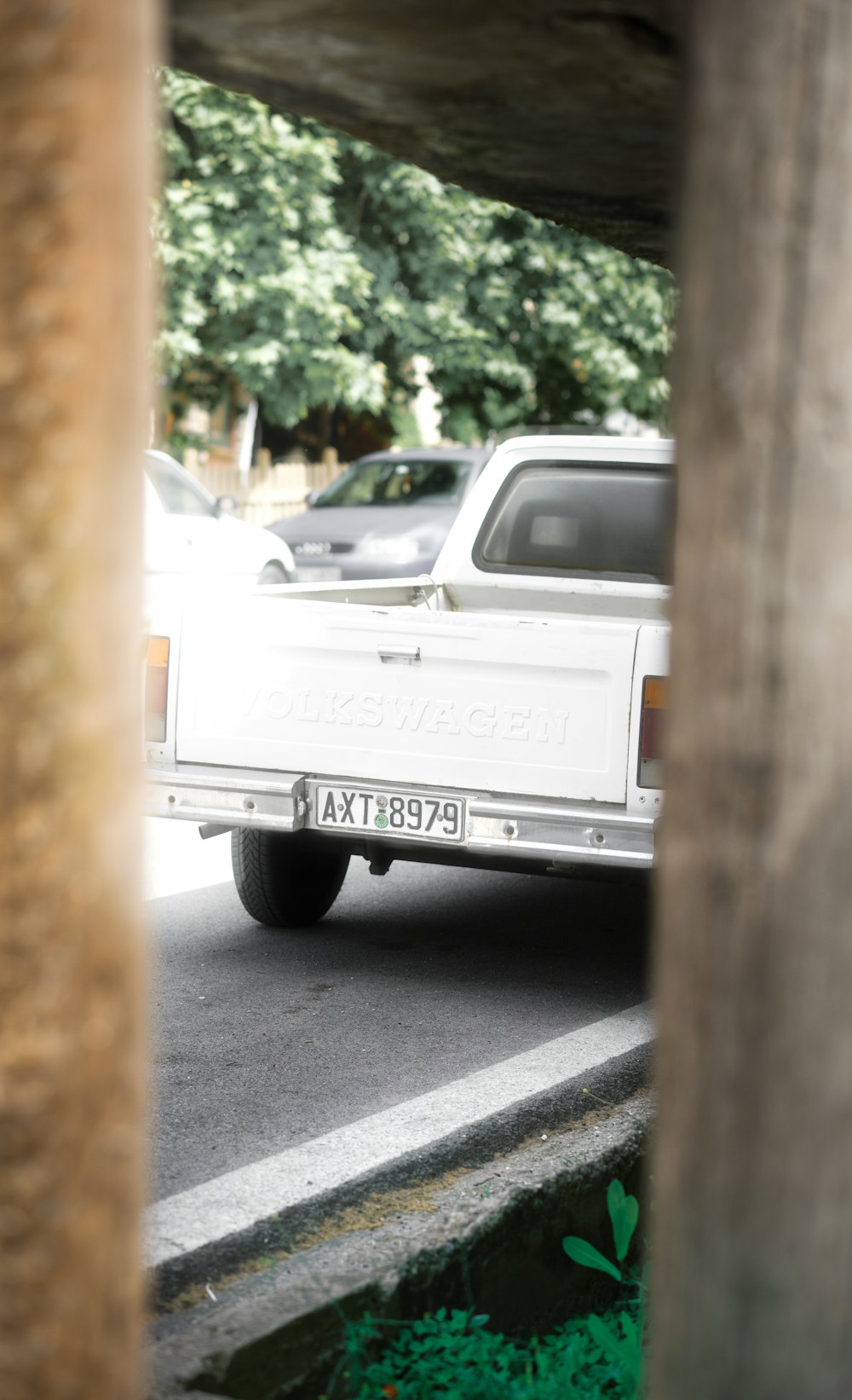 a white pick up truck driving under a bridge