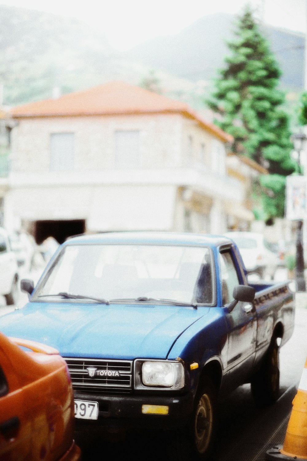 a blue pick up truck driving down a street