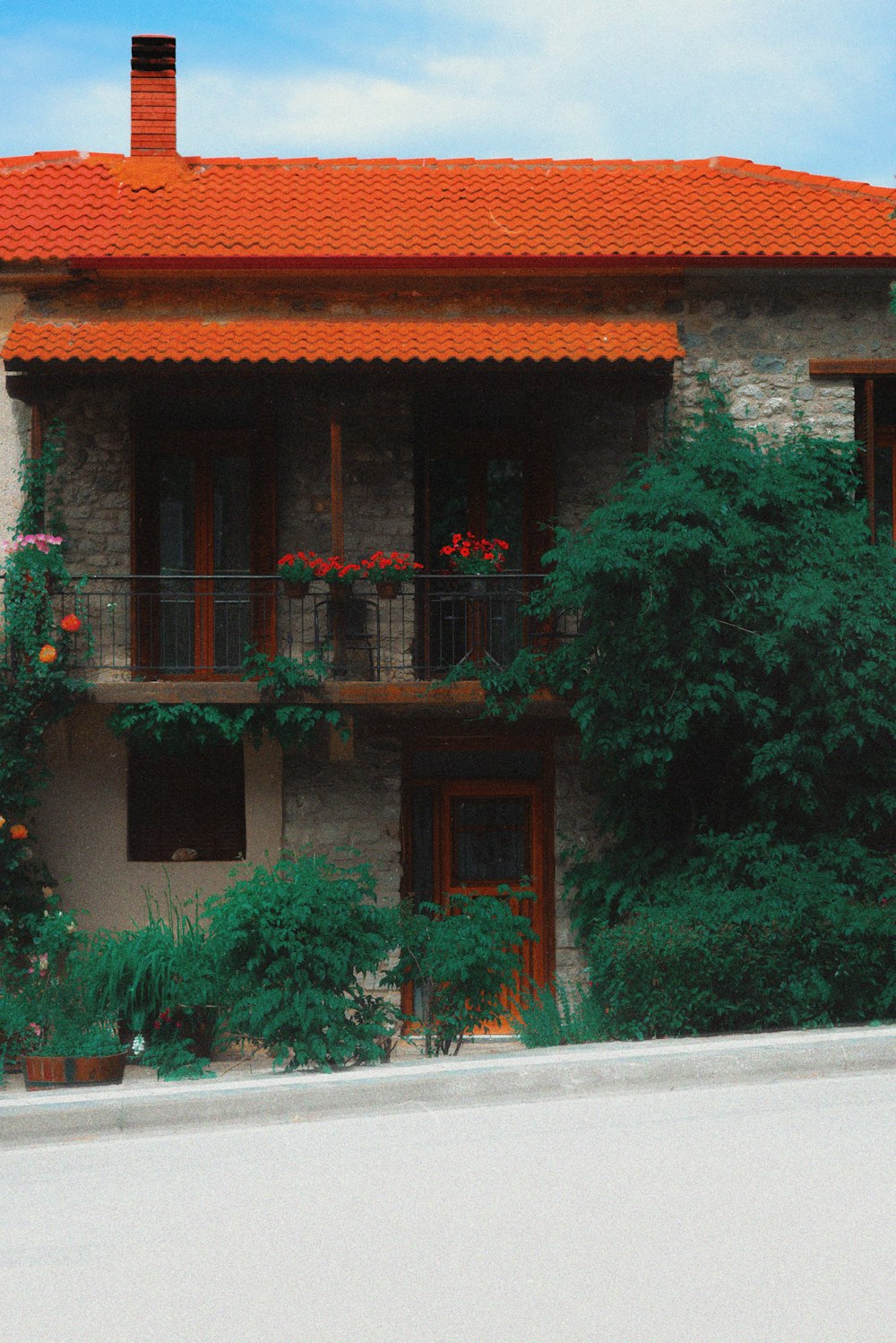 a building with a red roof and balcony