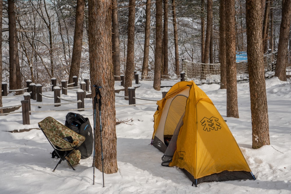 a tent in the snow next to a backpack