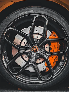 Detail shot of a high-performance car wheel spinning on an open road.