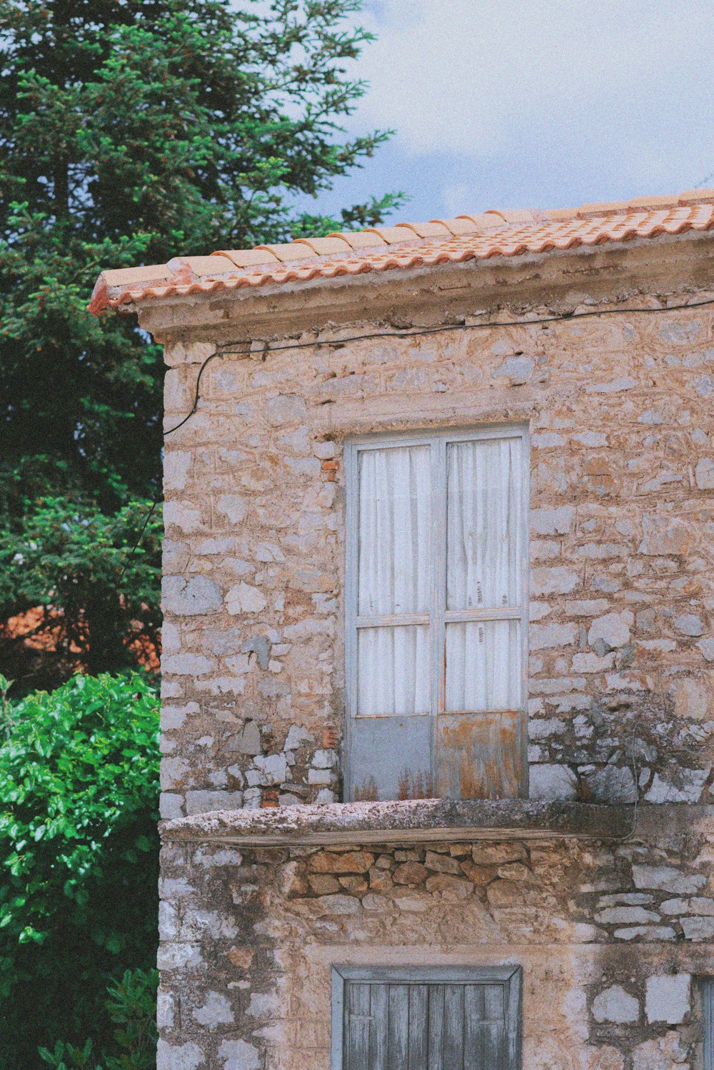 an old brick building with a cat sitting on the window sill