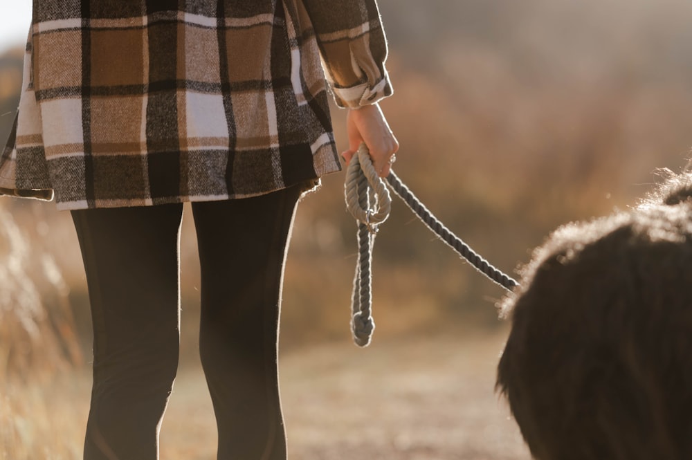 a woman walking a dog on a leash