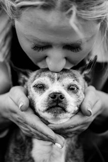 a woman holding a dog in her hands