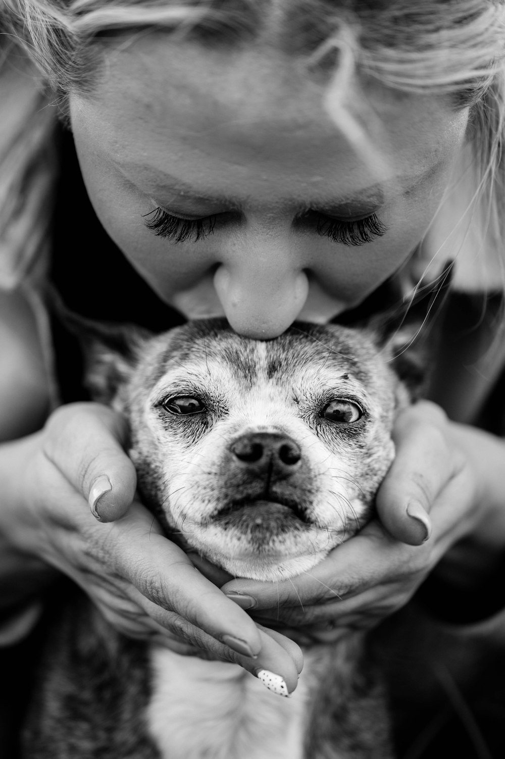 a woman holding a dog in her hands