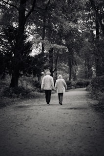 a couple of people walking down a dirt road