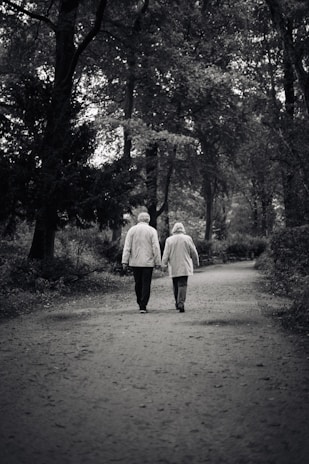 a couple of people walking down a dirt road