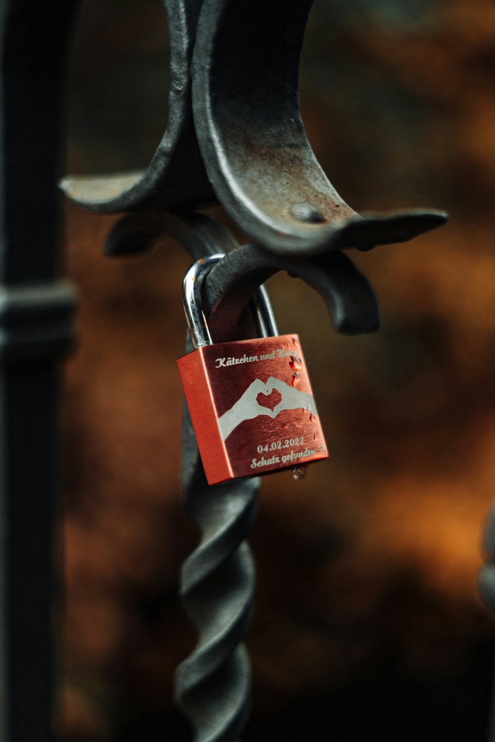 a red padlock attached to a metal gate