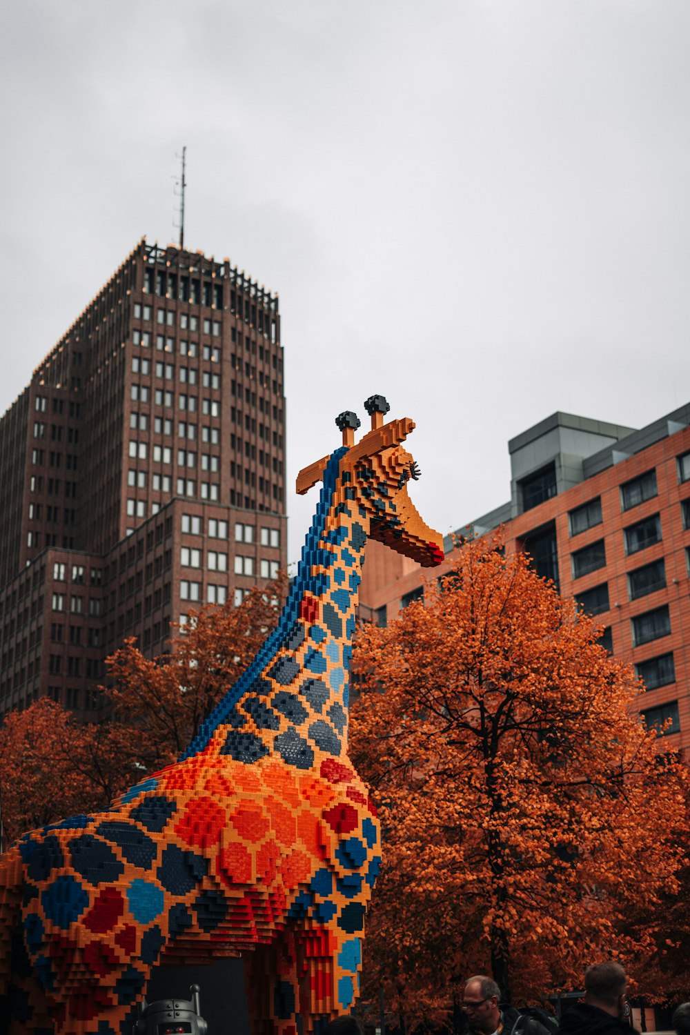 a giant giraffe made out of legos in a city