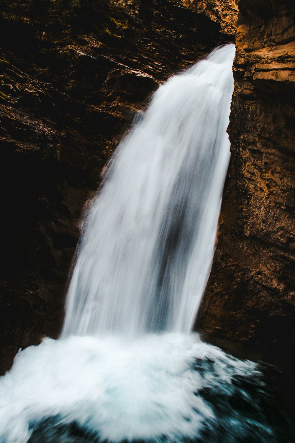 a waterfall with a person standing in the water