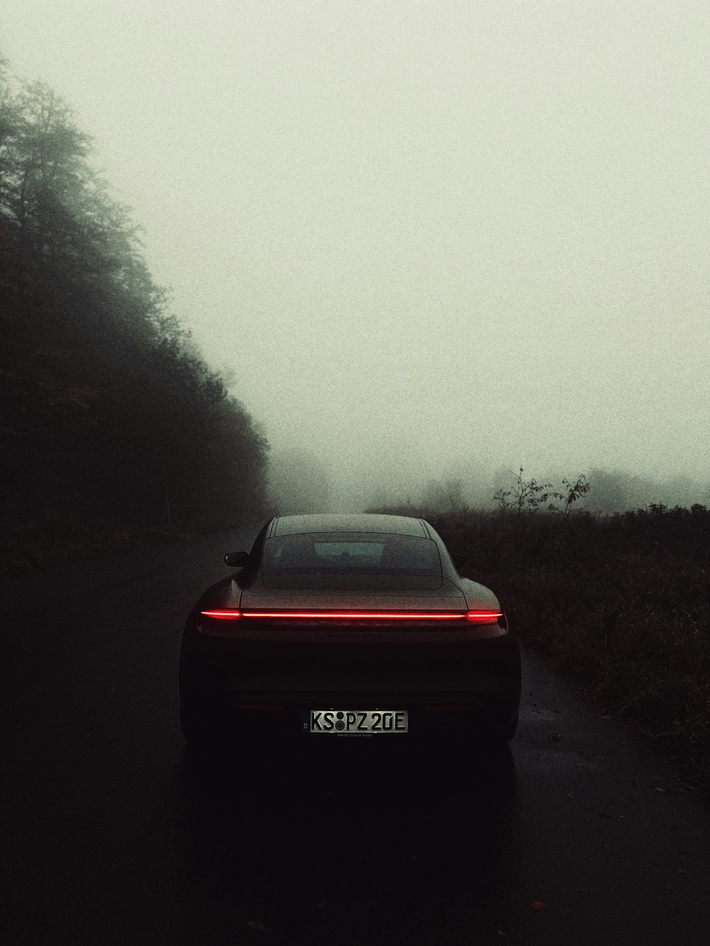 a car driving down a road in the fog