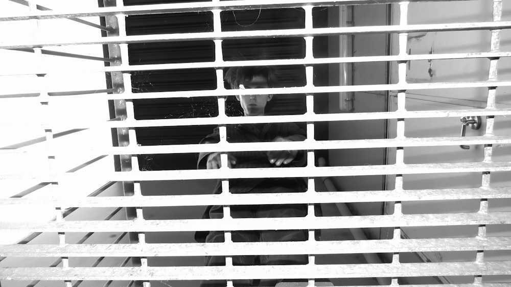 a person standing behind bars in a window