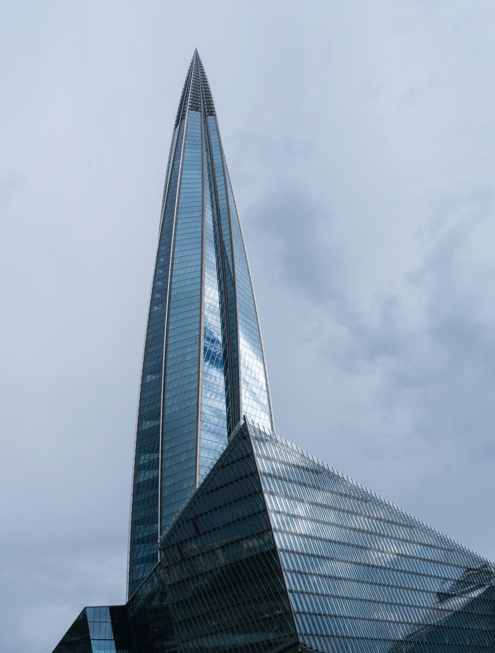a very tall glass building with a sky background