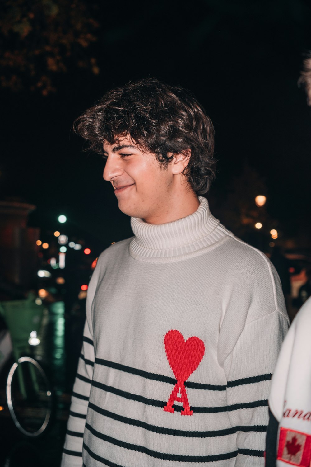 a young man wearing a sweater with a heart on it